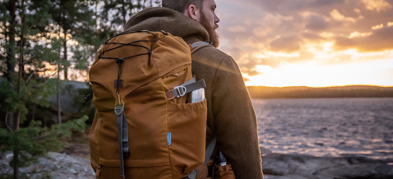 Mann mit Wanderrucksack am See Mann mit Rucksack am See